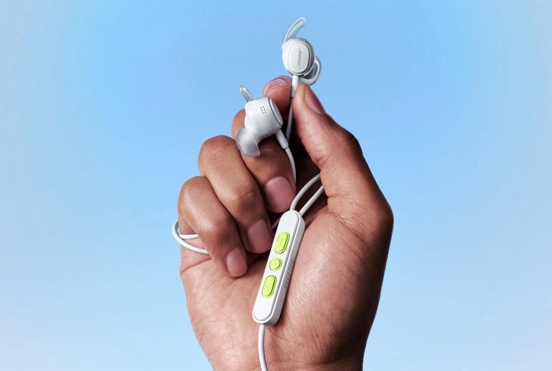 Fones de ouvido intra-auriculares com fio da Bose sobre uma superfície clara